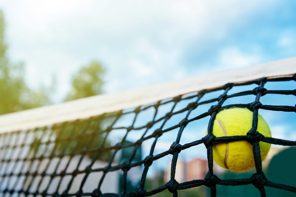 Close-up photo of tennis ball hitting to net. Sport concept.